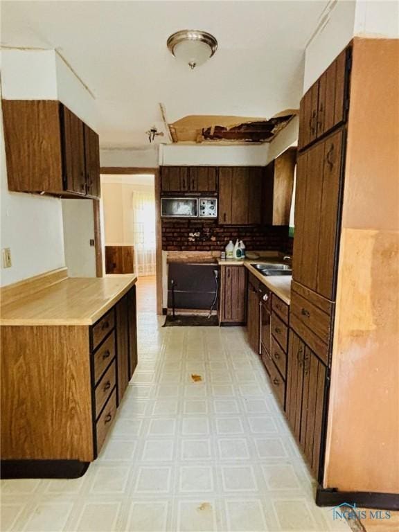 4136 Berwick Ave, Toledo, OH 43612 - kitchen featuring light countertops, backsplash, light floors, and dark brown cabinets
