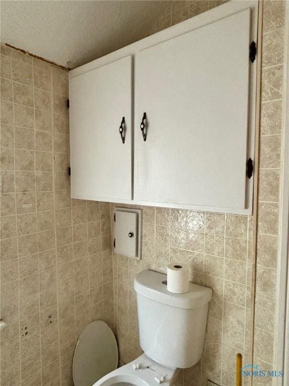 4136 Berwick Ave, Toledo, OH 43612 - bathroom featuring a textured ceiling and tile walls