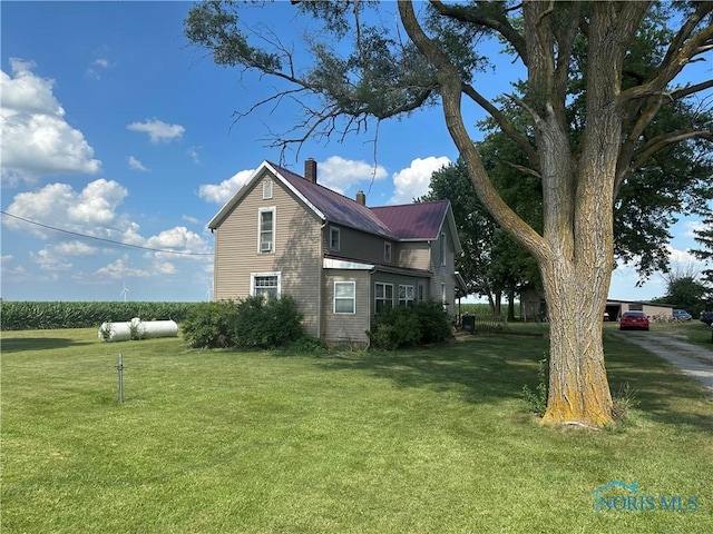 11080 Rd 21, Antwerp, OH 45813 - view of side of property featuring a chimney, a yard, and a metal roof