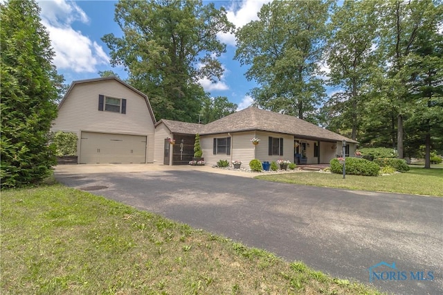 8411 Larch Rd, Toledo, OH 43617 - view of front of property featuring a garage, asphalt driveway, a gambrel roof, and a front yard