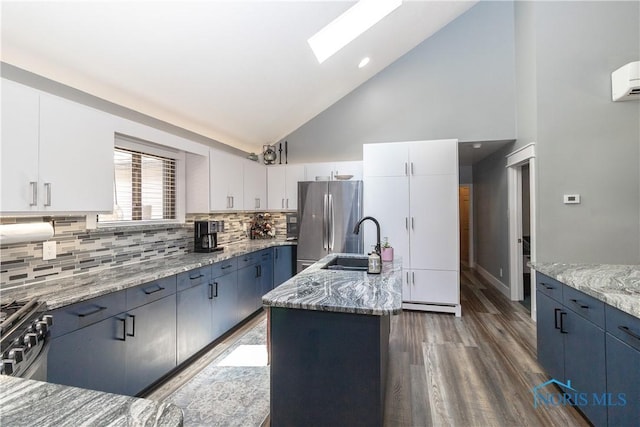 8411 Larch Rd, Toledo, OH 43617 - kitchen featuring appliances with stainless steel finishes, light stone countertops, backsplash, wood finished floors, and high vaulted ceiling