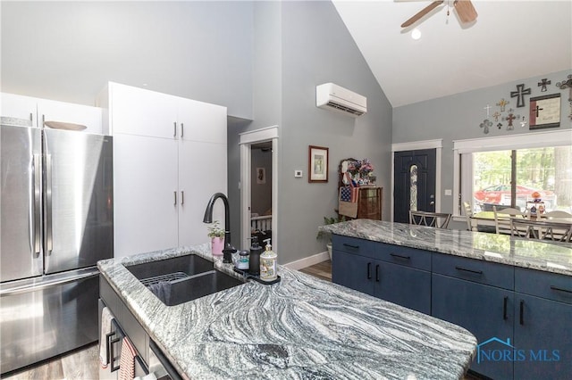 8411 Larch Rd, Toledo, OH 43617 - kitchen with freestanding refrigerator, a wall unit AC, high vaulted ceiling, wood finished floors, and light stone countertops