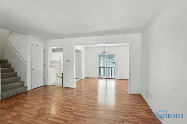 1939 Macomber St, Toledo, OH 43606 - unfurnished living room featuring light wood finished floors and stairs