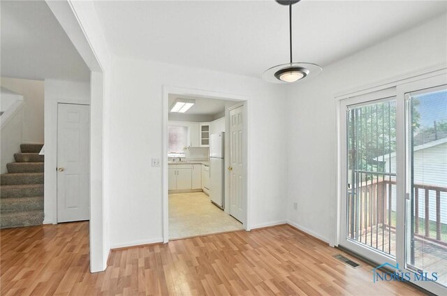 1939 Macomber St, Toledo, OH 43606 - unfurnished dining area with light wood-style flooring and stairs