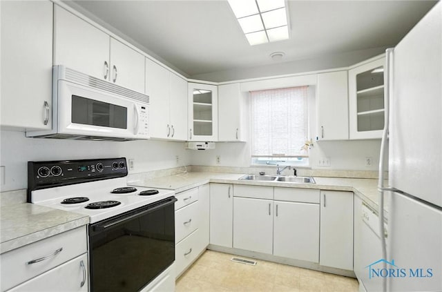 1939 Macomber St, Toledo, OH 43606 - kitchen featuring white appliances, light countertops, white cabinetry, and glass insert cabinets