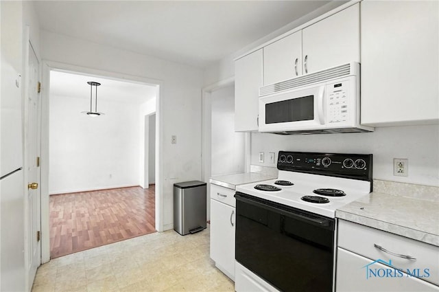 1939 Macomber St, Toledo, OH 43606 - kitchen featuring white microwave, range with electric cooktop, light countertops, and white cabinetry
