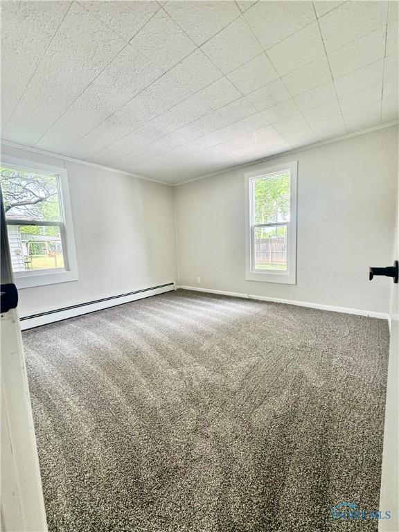 339 N E Ave, Deshler, OH 43516 - empty room with baseboard heating, plenty of natural light, carpet, and crown molding