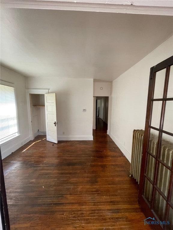 421 Oswald St, Toledo, OH 43605 - empty room featuring wood finished floors, lofted ceiling, and radiator