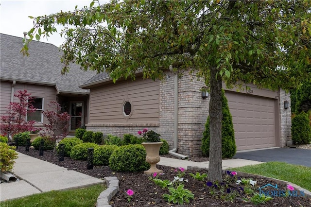1533 Eaglebrook Rd Unit 1533, Toledo, OH 43615 - view of property exterior featuring asphalt driveway, roof with shingles, brick siding, and an attached garage