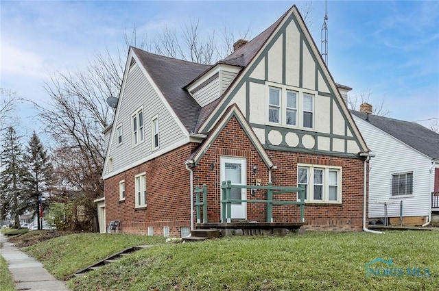 2517 Montebello Rd, Toledo, OH 43607 - tudor home with brick siding, a front yard, stucco siding, and a shingled roof
