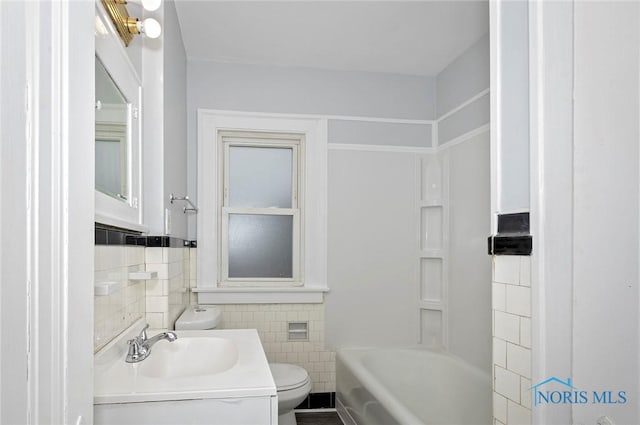 2517 Montebello Rd, Toledo, OH 43607 - full bath with tile walls, washtub / shower combination, vanity, and wainscoting