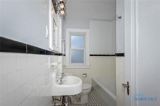 2517 Montebello Rd, Toledo, OH 43607 - bathroom featuring a bath, tile walls, tile patterned flooring, and wainscoting