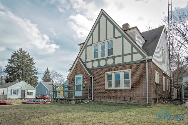 2517 Montebello Rd, Toledo, OH 43607 - tudor home with brick siding, a chimney, a front lawn, and stucco siding