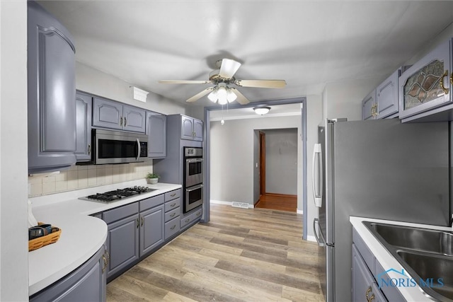 5201 Arbor Way, Sylvania, OH 43560 - kitchen with appliances with stainless steel finishes, gray cabinetry, a ceiling fan, tasteful backsplash, and light countertops