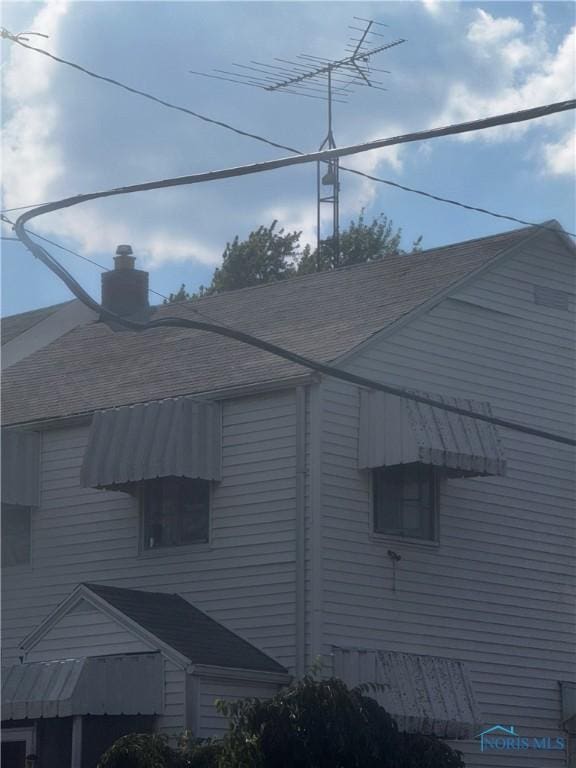 1421 N Ravine Pkwy, Toledo, OH 43605 - view of home's exterior featuring a shingled roof and a chimney