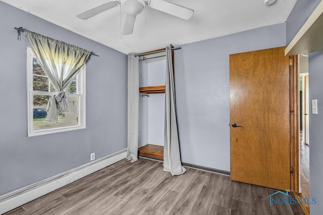 3253 Radford Dr, Toledo, OH 43614 - unfurnished bedroom featuring a baseboard radiator, a closet, wood finished floors, and ceiling fan
