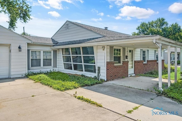 3253 Radford Dr, Toledo, OH 43614 - view of front of home with concrete driveway, brick siding, and a shingled roof