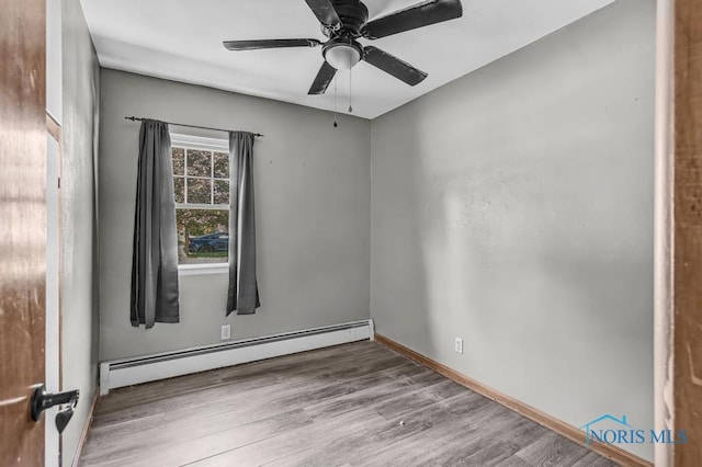 3253 Radford Dr, Toledo, OH 43614 - empty room with baseboard heating, wood finished floors, and a ceiling fan