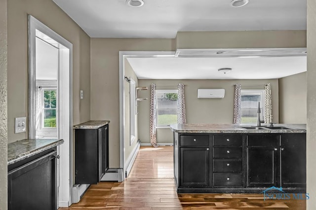 3253 Radford Dr, Toledo, OH 43614 - kitchen featuring dark cabinets, wood finished floors, and a wall unit AC