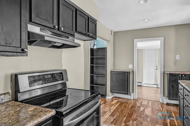 3253 Radford Dr, Toledo, OH 43614 - kitchen with stainless steel range with electric stovetop, under cabinet range hood, wood finished floors, dark cabinetry, and baseboard heating
