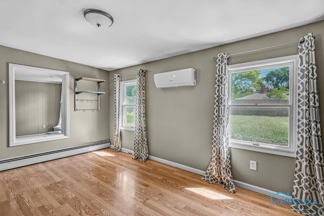 3253 Radford Dr, Toledo, OH 43614 - spare room featuring a wall mounted AC, wood finished floors, and a baseboard radiator