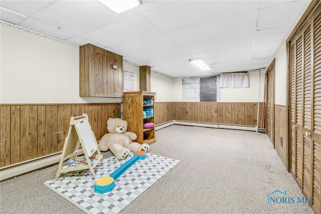 3122 Winston Blvd, Toledo, OH 43614 - playroom with a baseboard heating unit, a drop ceiling, wood walls, a wainscoted wall, and carpet flooring