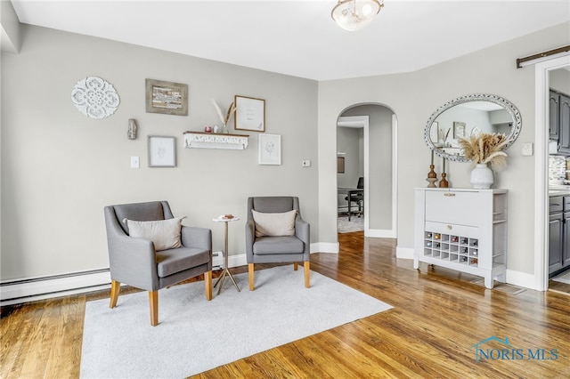 3122 Winston Blvd, Toledo, OH 43614 - sitting room featuring arched walkways, baseboard heating, and wood finished floors