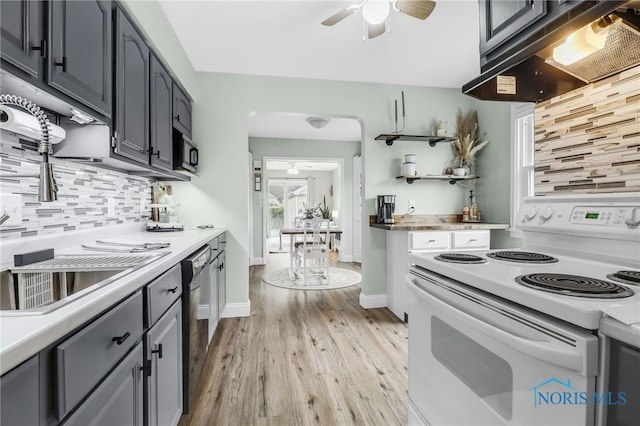 3122 Winston Blvd, Toledo, OH 43614 - kitchen with white range with electric stovetop, a ceiling fan, under cabinet range hood, light wood-style flooring, and backsplash
