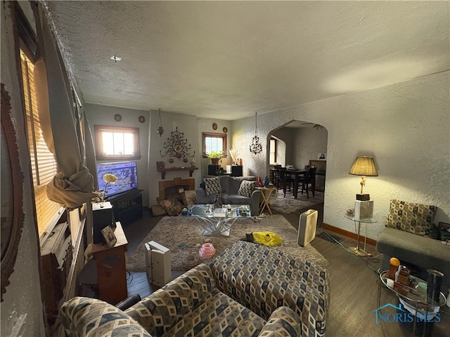 1336 Craigwood Rd, Toledo, OH 43612 - living area featuring arched walkways, wood finished floors, a textured wall, and a textured ceiling