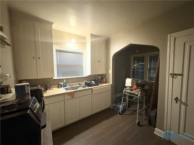1336 Craigwood Rd, Toledo, OH 43612 - kitchen featuring arched walkways, dark wood-style flooring, white cabinets, and light countertops