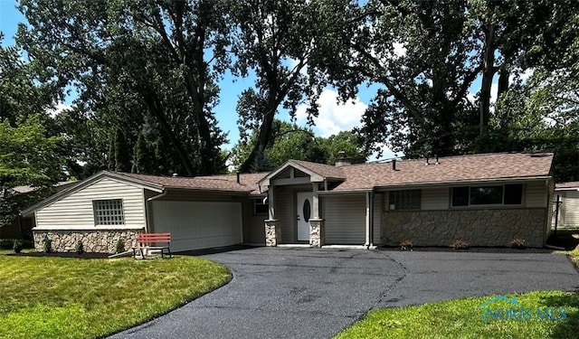 2929 Wicklow Rd, Toledo, OH 43606 - ranch-style house with stone siding, an attached garage, asphalt driveway, and a front lawn