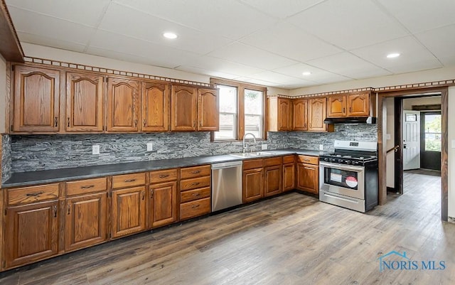 1553 Flormar Ct, Toledo, OH 43612 - kitchen featuring stainless steel appliances, brown cabinets, a paneled ceiling, healthy amount of natural light, and dark countertops