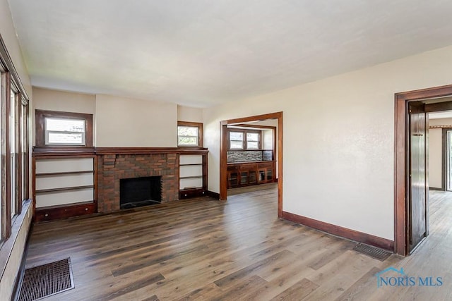 1553 Flormar Ct, Toledo, OH 43612 - unfurnished living room featuring wood finished floors and a brick fireplace