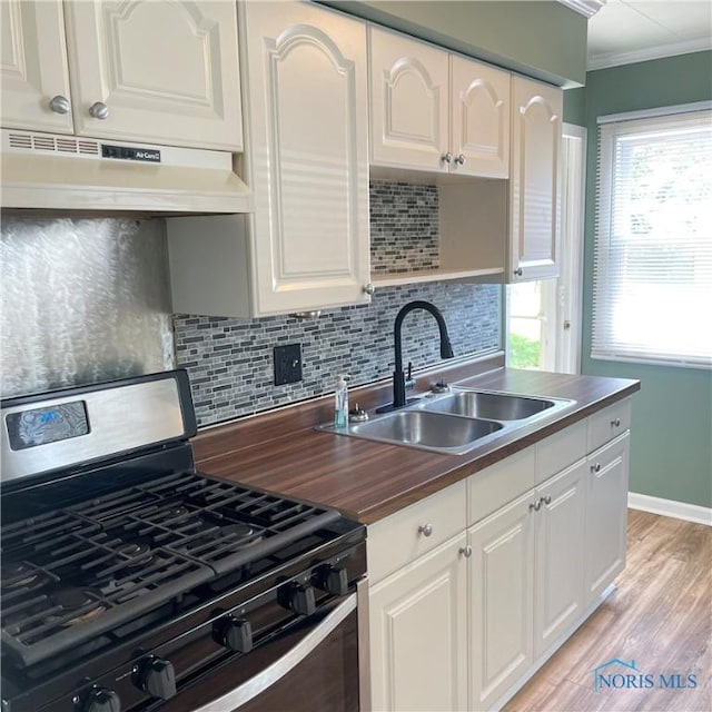 415 W Northgate Pkwy, Toledo, OH 43612 - kitchen with stainless steel range with gas stovetop, under cabinet range hood, decorative backsplash, crown molding, and light wood-type flooring