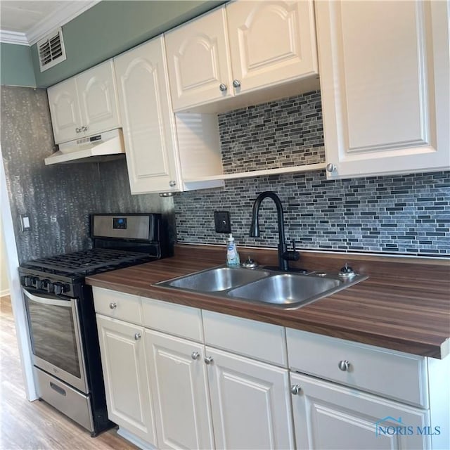 415 W Northgate Pkwy, Toledo, OH 43612 - kitchen featuring stainless steel range with gas stovetop, under cabinet range hood, wooden counters, ornamental molding, and white cabinetry