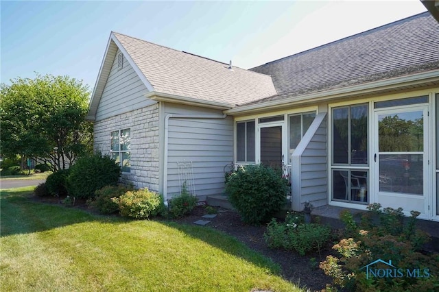 7673 Brookstone Dr Unit U7673, Findlay, OH 45840 - view of side of property featuring a lawn and roof with shingles