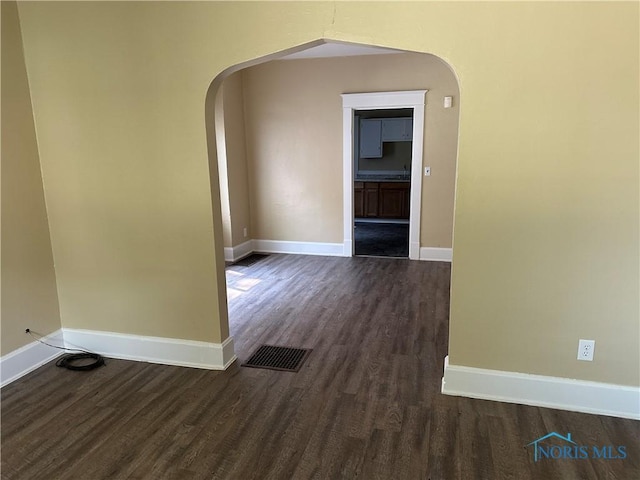 540 E Central Ave, Toledo, OH 43608 - empty room with arched walkways and dark wood finished floors
