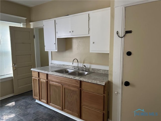 540 E Central Ave, Toledo, OH 43608 - kitchen featuring white cabinetry, light countertops, brown cabinetry, and dark stone finish flooring
