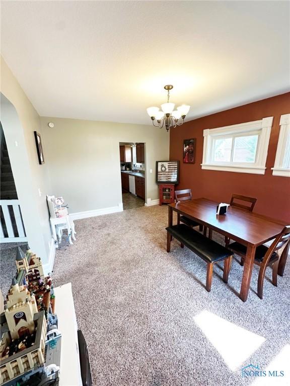 201 E Saffell Ave, Sycamore, OH 44882 - dining area with a chandelier, light colored carpet, and arched walkways
