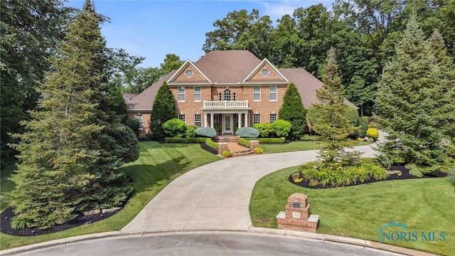 1616 Firestone Dr, Findlay, OH 45840 - colonial inspired home with curved driveway, a front lawn, french doors, and brick siding