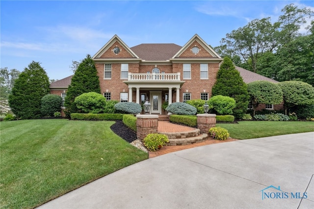 1616 Firestone Dr, Findlay, OH 45840 - colonial home featuring a front lawn, brick siding, and a balcony