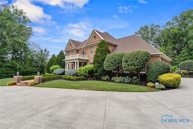 1616 Firestone Dr, Findlay, OH 45840 - colonial house featuring a balcony, a front yard, and brick siding