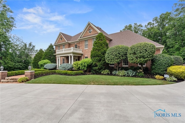 1616 Firestone Dr, Findlay, OH 45840 - georgian-style home featuring a balcony, a front lawn, and brick siding