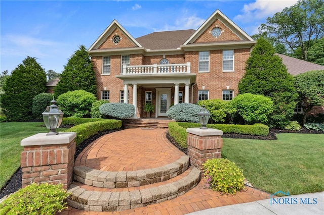 1616 Firestone Dr, Findlay, OH 45840 - georgian-style home featuring a balcony, brick siding, and a front yard