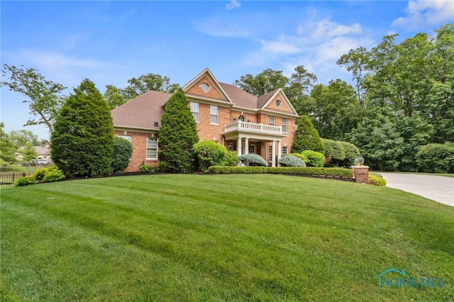 1616 Firestone Dr, Findlay, OH 45840 - colonial-style house featuring a balcony, a front yard, brick siding, and driveway