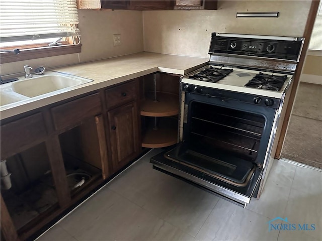 1623 W Central Ave, Toledo, OH 43606 - kitchen with black gas stove, light countertops, and dark brown cabinets