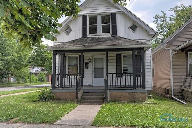 452 E Park St, Toledo, OH 43608 - view of front of house featuring a front lawn, a porch, and board and batten siding