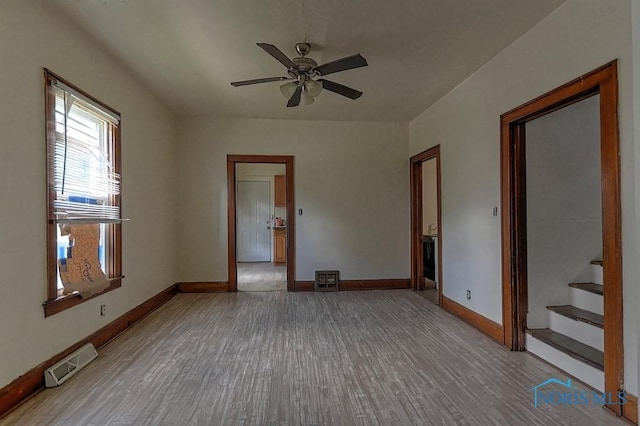 452 E Park St, Toledo, OH 43608 - unfurnished room featuring wood finished floors, stairs, and a ceiling fan