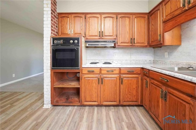 601 Edith Ave, Findlay, OH 45840 - kitchen with black oven, under cabinet range hood, brown cabinetry, and light wood-type flooring