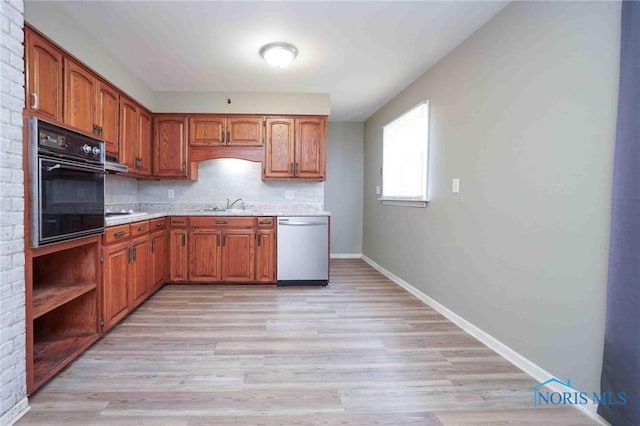 601 Edith Ave, Findlay, OH 45840 - kitchen featuring black oven, dishwasher, light countertops, brown cabinetry, and light wood-type flooring